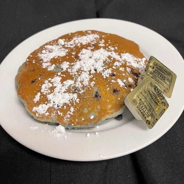 3 Blueberry Pancakes Dusted with Powdered Sugar.