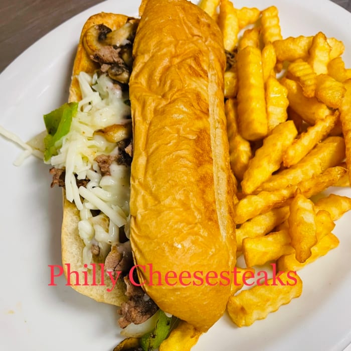 Philly Cheesesteak Sandwich with fries.